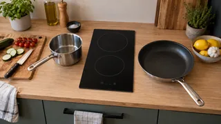 Plaque domino à deux zones dans une kitchenette, avec casserole et poêle prêtes à utiliser
