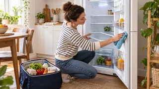 Nettoyage doux de l’intérieur d’un réfrigérateur dans une petite cuisine
